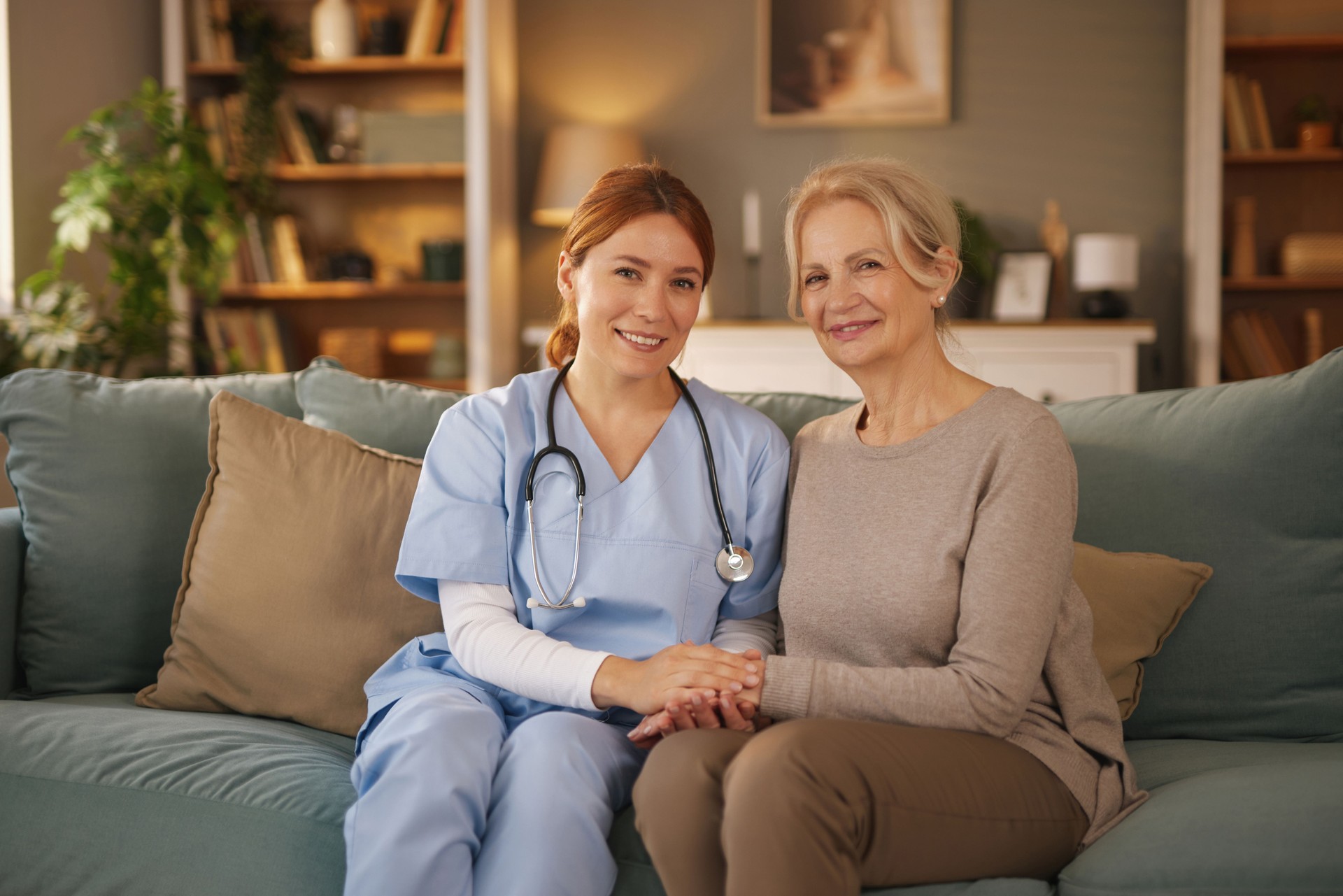 Nurse holding hands of a senior woman during home visit